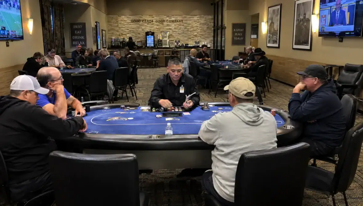 Players take part in a low-stakes live poker game at tables inside a local cardroom.